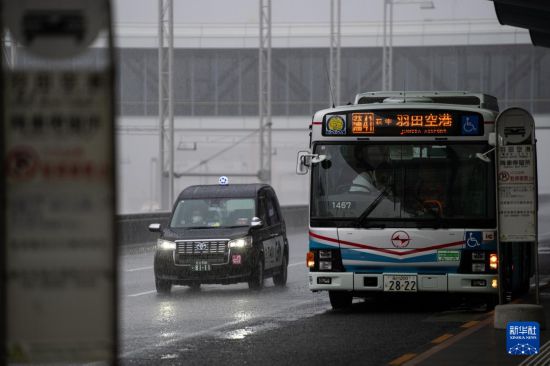 8月16日，在日本东京羽田机场，车辆行驶在暴雨中。新华社记者 张笑宇 摄