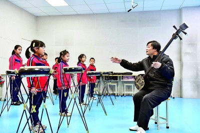 图为12月30日，在惠民县胡集镇第一小学，老师指导学生学习西河大鼓。新华社记者 郭绪雷摄